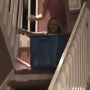 Blonde glisse dans escaliers avec panier linge